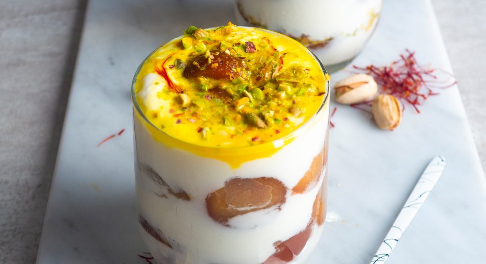 indian dessert parfait layered with gulab jamun and yoghurt, and topped with saffron milk mixture, chopped pistachios and saffron.