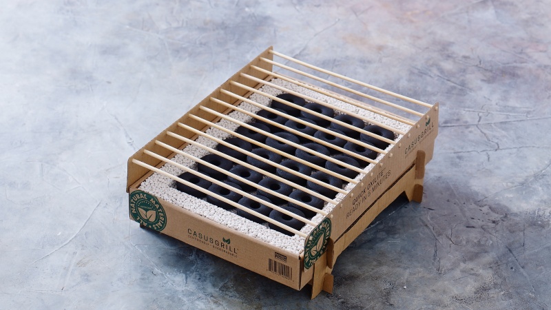 A portable barbecue grill made with cardboard and bamboo sticks, set against a marbled grey background